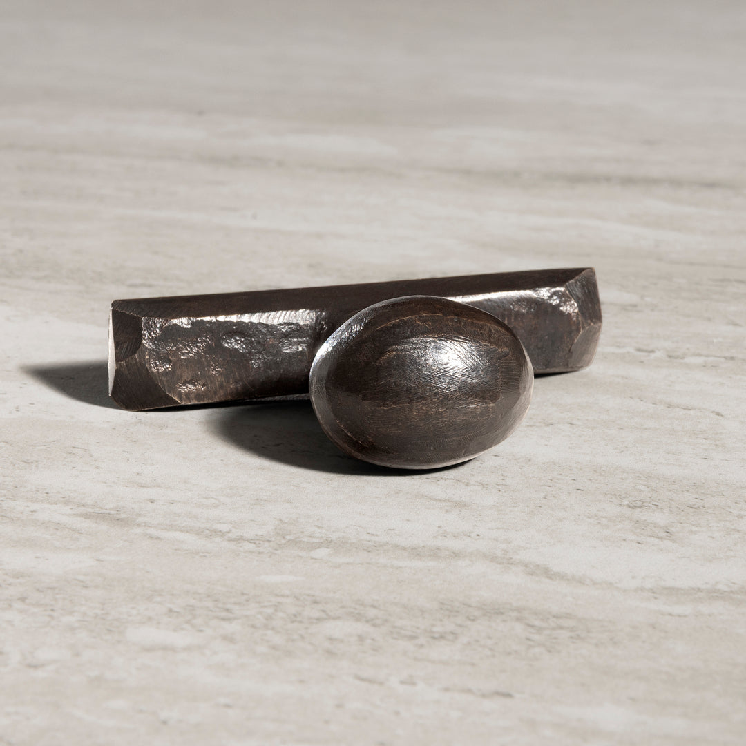 Sculptural bronze cabinet knob with smooth oval front and angular bronze bar design