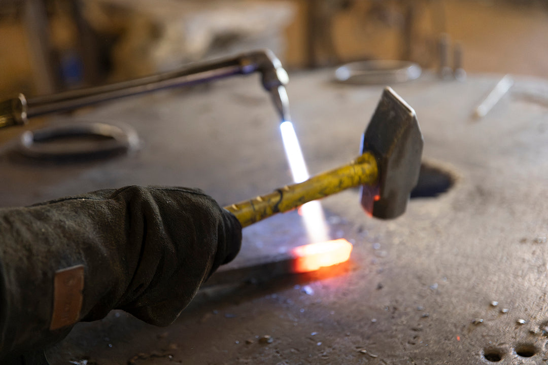 Heated iron being shaped by hand in the Ashore Lighting workshop as part of the traditional fabrication process for designer lighting.