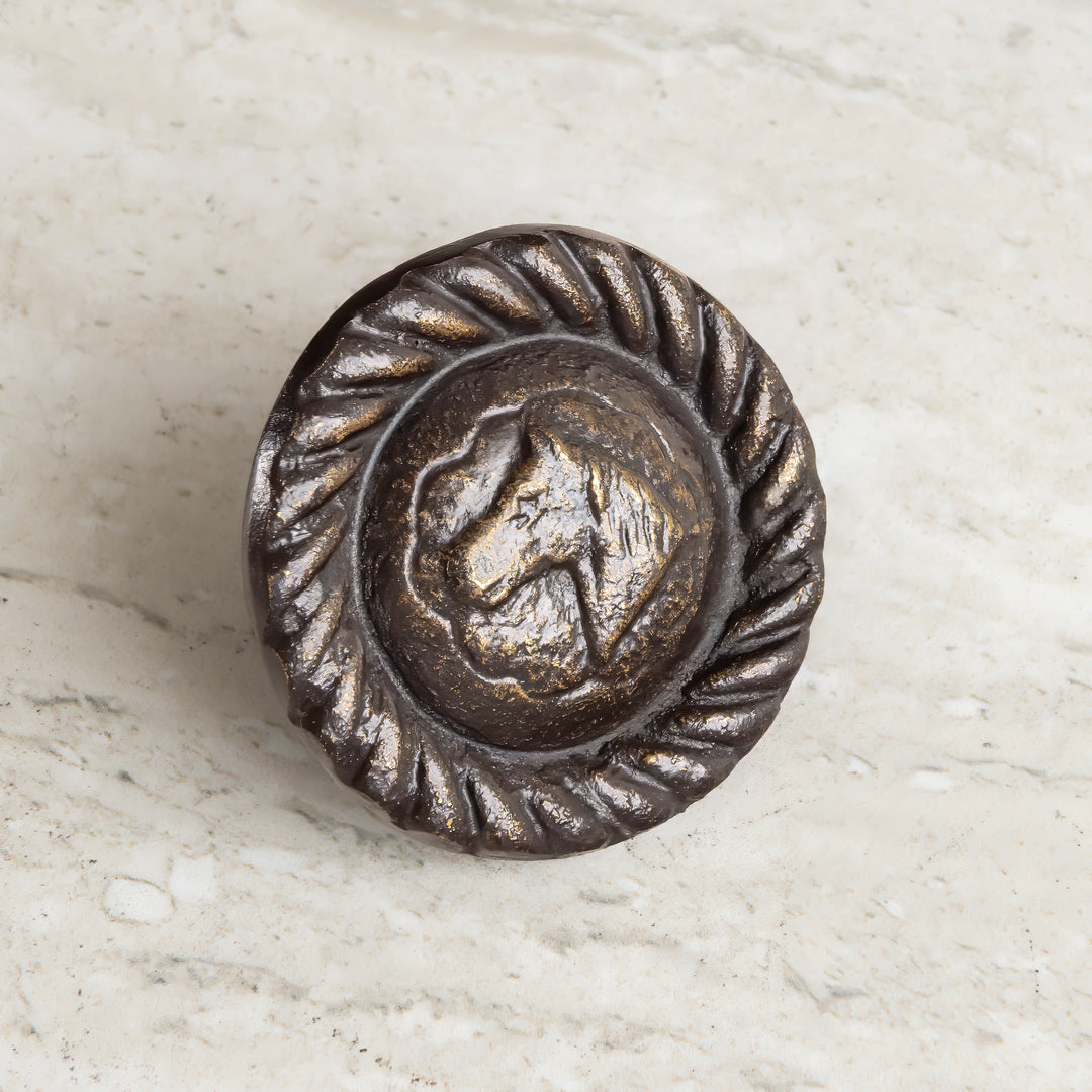 Handcast bronze cabinet knob with raised horse medallion and rope-edge border