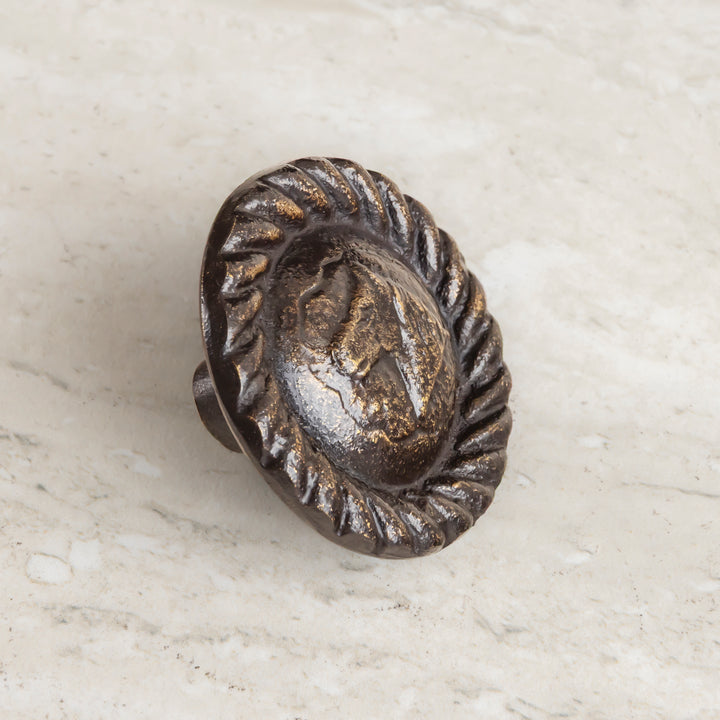 Bronze cabinet hardware knob featuring horse profile medallion and textured border