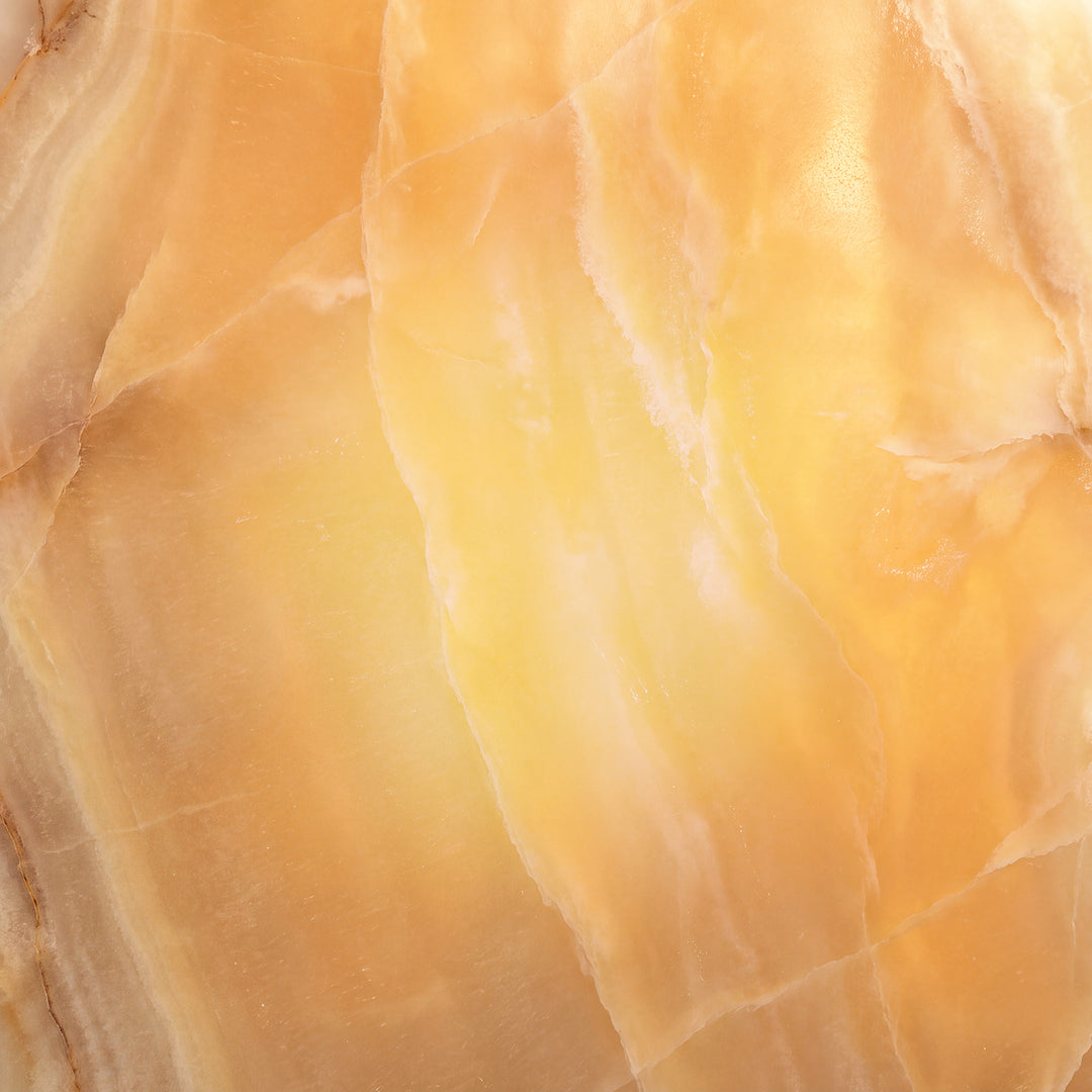 Natural Amber alabaster illuminated for designer lighting, showing warm golden translucency, mineral movement, and individual stone variation.