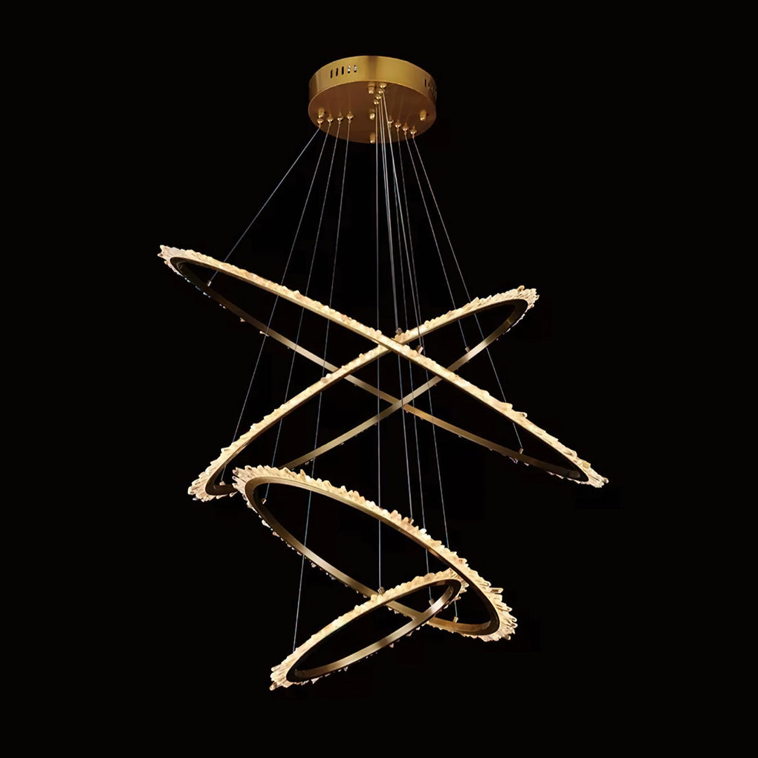 Orbit four-ring wrought iron quartz chandelier with intersecting suspended circular rings lined in illuminated natural quartz formations.