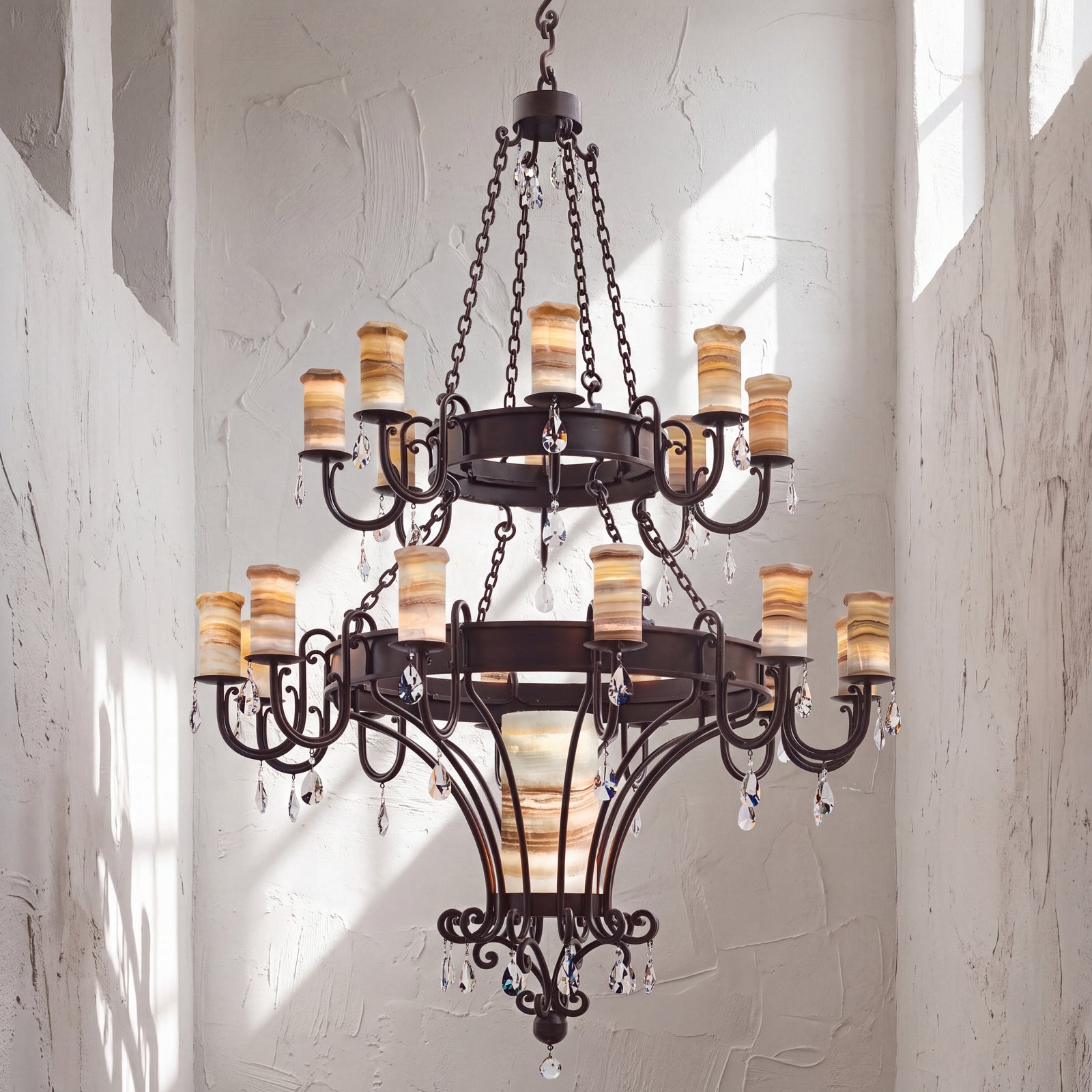Trevi heirloom two-tier alabaster chandelier with sculptural ironwork, luminous natural stone shades, and suspended faceted crystal accents.