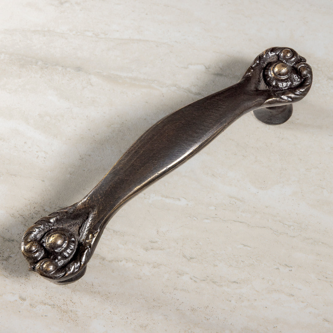 Valencia Pull bronze cabinet hardware with decorative rosette ends and tapered center grip