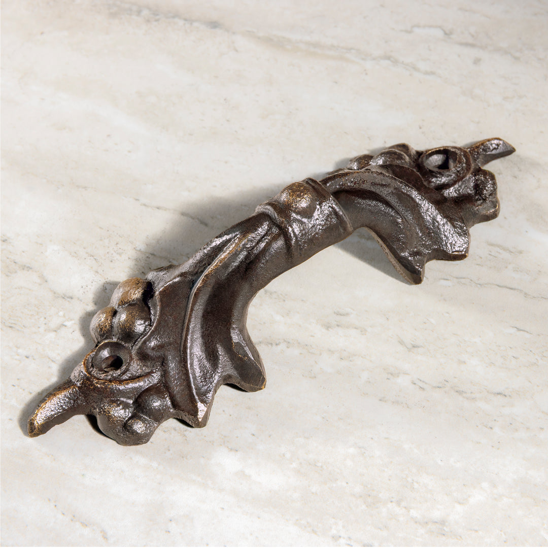 Vigna bronze pull with sculpted grape cluster detailing shown in angled view on stone surface