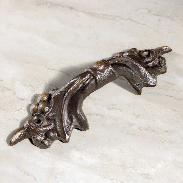 Vigna bronze pull with sculpted grape cluster detailing shown in angled view on stone surface