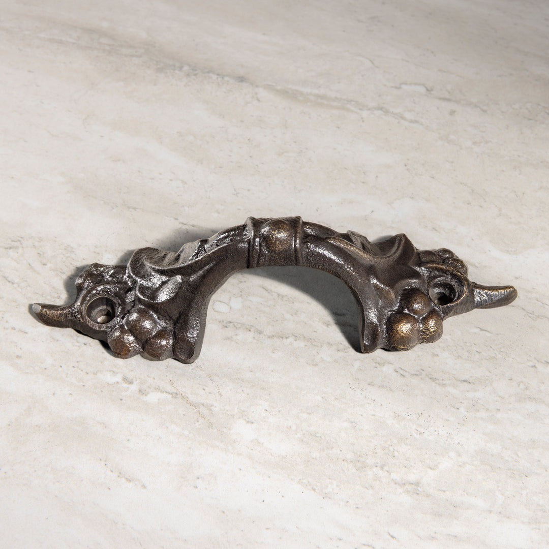 Vigna bronze cabinet pull with decorative grape clusters and arched center grip front view